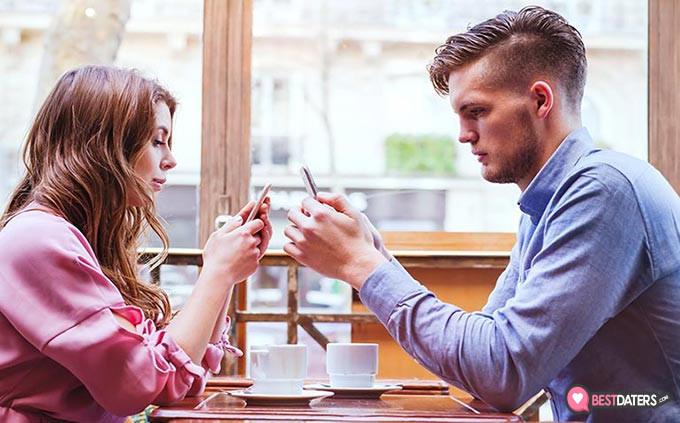 Melhores sites de namoro: um casal em um encontro em seus telefones.